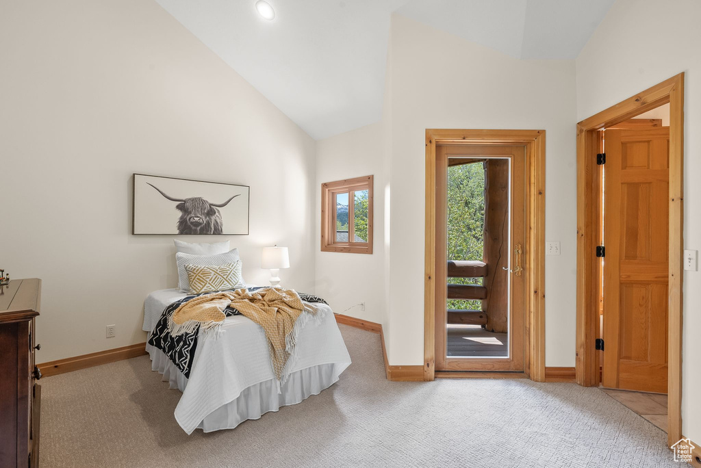 Carpeted bedroom with high vaulted ceiling and access to outside