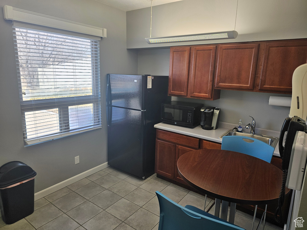 Kitchen featuring sink, black appliances, and light tile floors