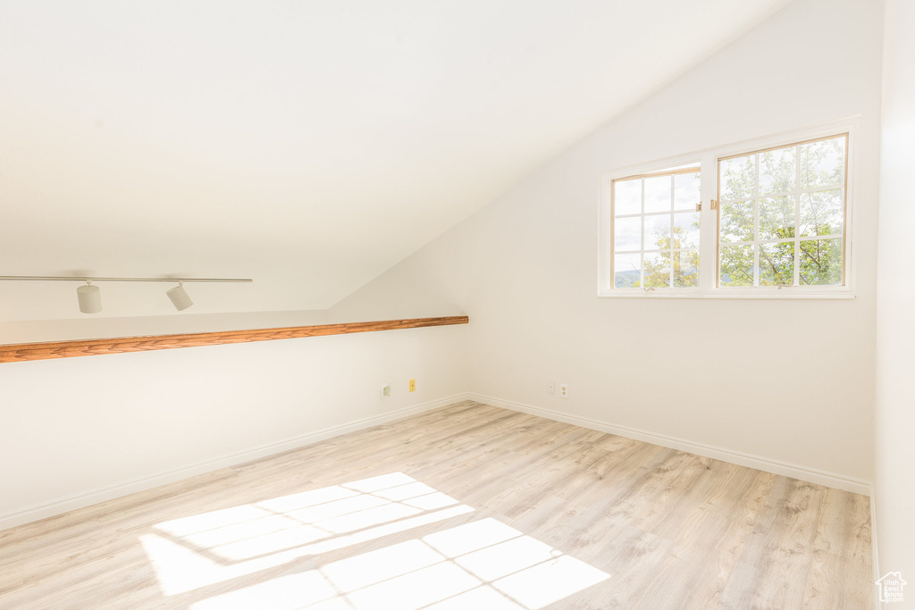 Bonus room with light hardwood / wood-style flooring and lofted ceiling