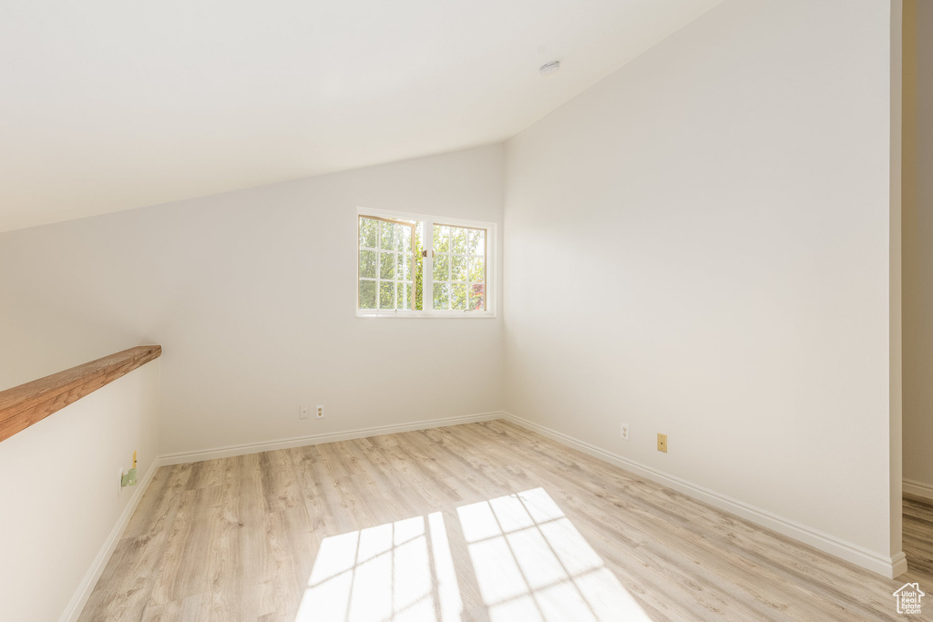 Empty room featuring light hardwood / wood-style flooring and lofted ceiling