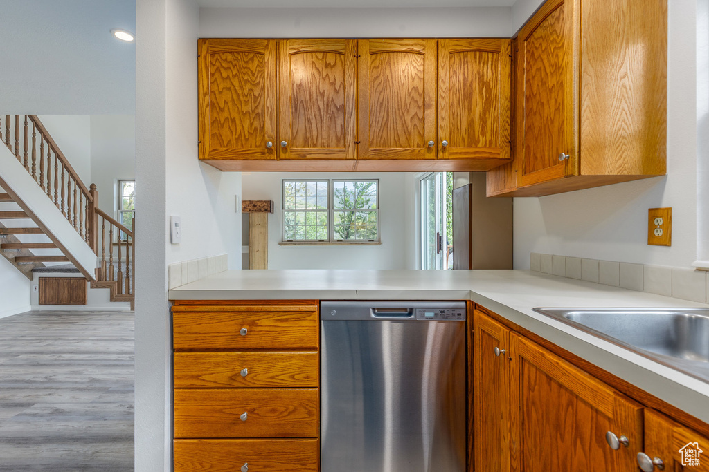 Kitchen with light hardwood / wood-style floors and stainless steel dishwasher