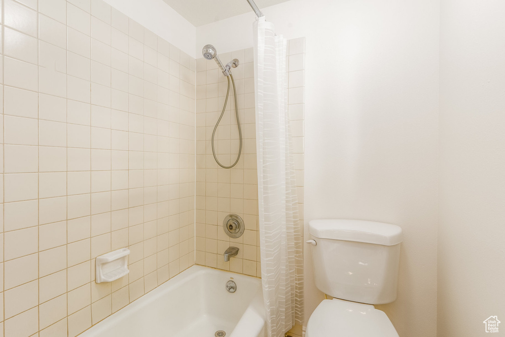 Bathroom with shower / tub combo with curtain and toilet