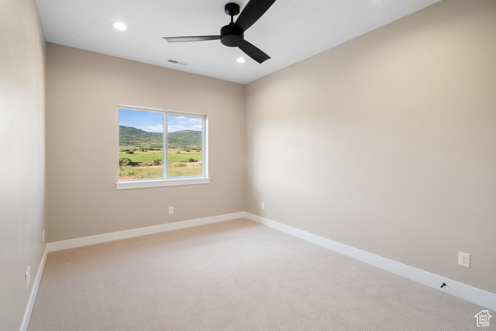 Carpeted empty room featuring ceiling fan