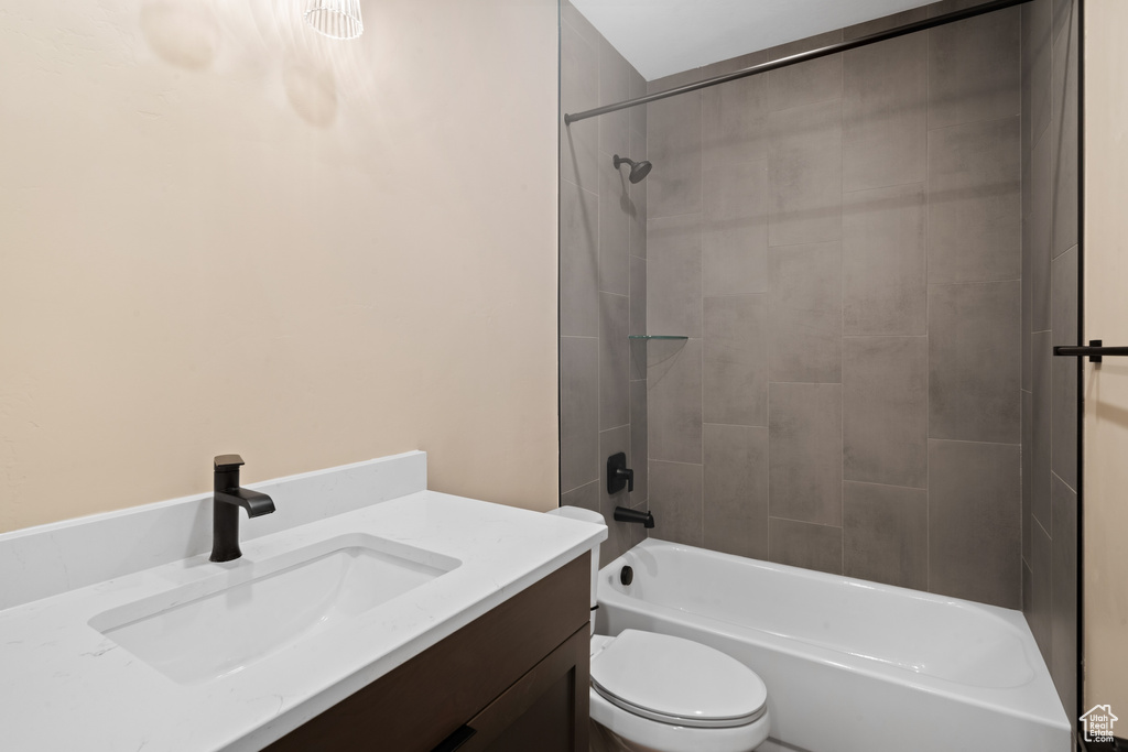 Full bathroom featuring toilet, tiled shower / bath combo, and vanity