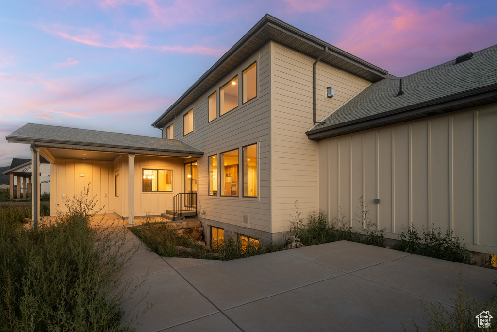 Back house at dusk featuring a patio