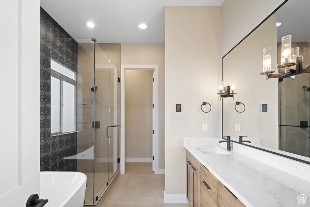 Bathroom with tile patterned floors, separate shower and tub, and vanity