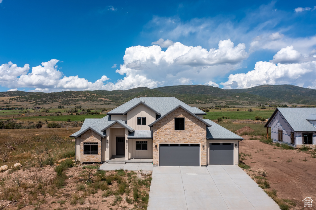 View of front of property with a mountain view and a garage