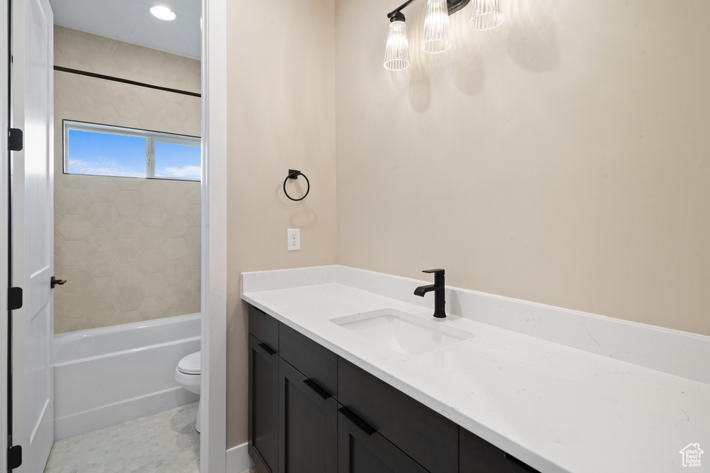 Full bathroom with tile patterned flooring, vanity, tiled shower / bath combo, and toilet