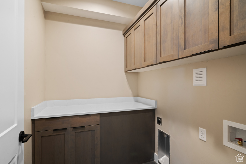 Clothes washing area featuring electric dryer hookup, cabinets, and hookup for a washing machine