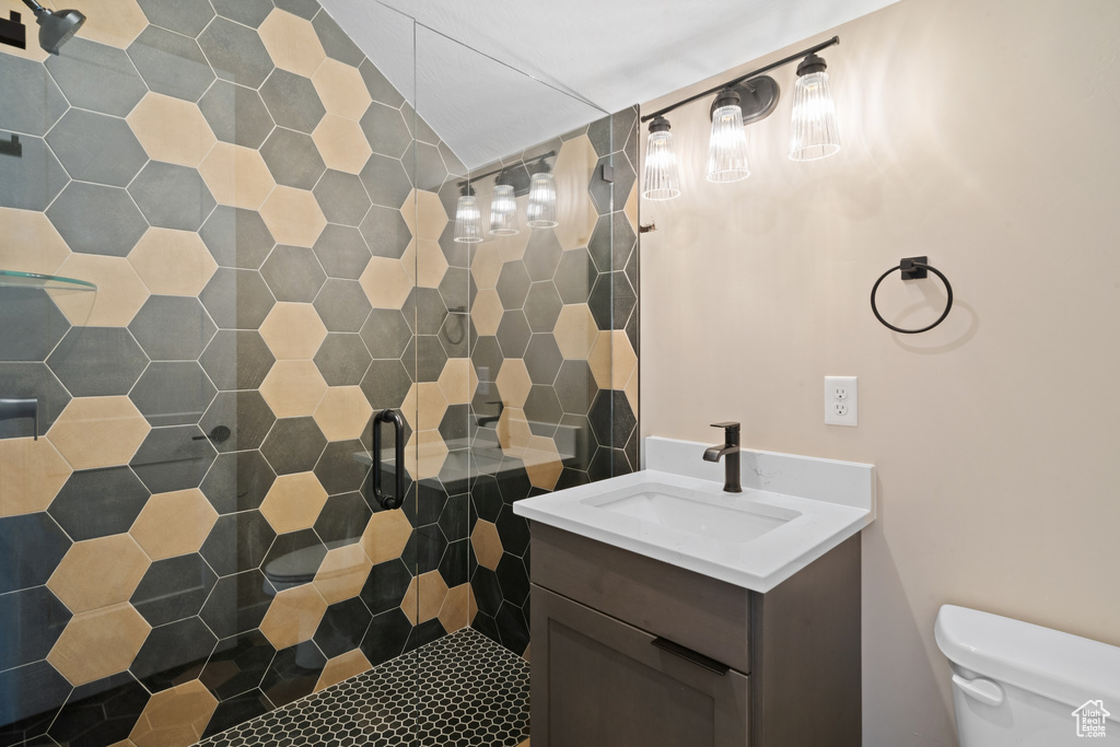 Bathroom with vanity, tiled shower, and toilet