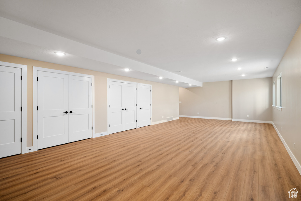 Basement with light hardwood / wood-style floors