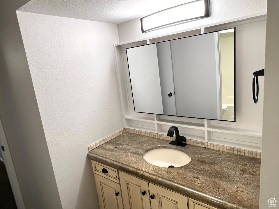 Bathroom with a textured ceiling and vanity