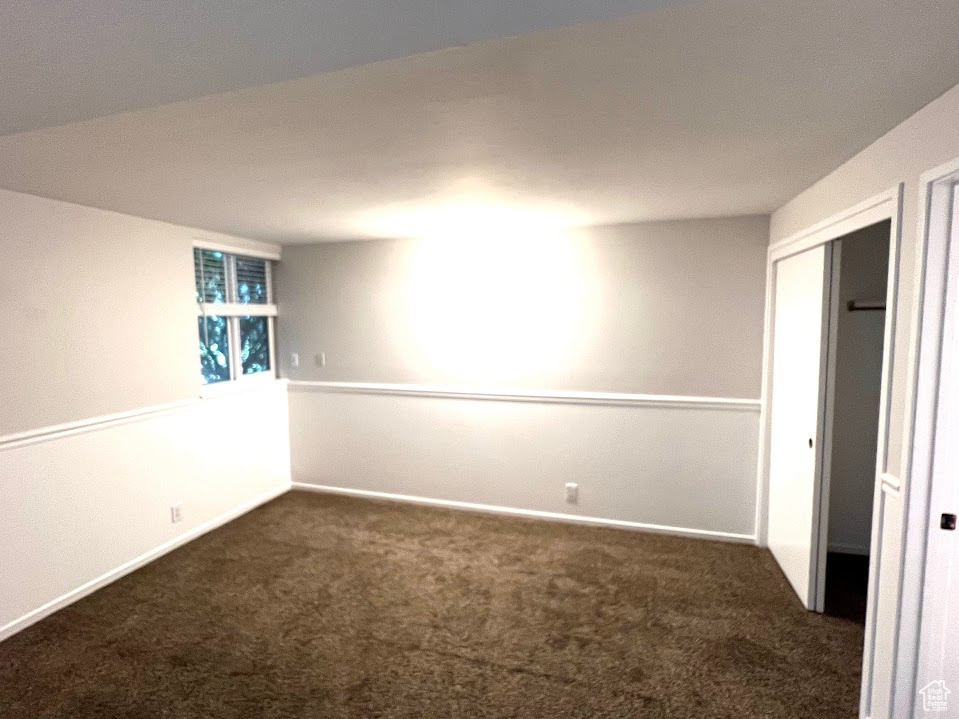 Unfurnished room featuring dark carpet