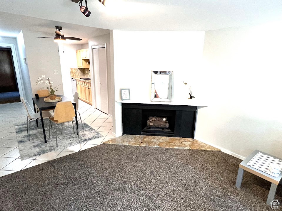 Unfurnished living room featuring light carpet, sink, and ceiling fan