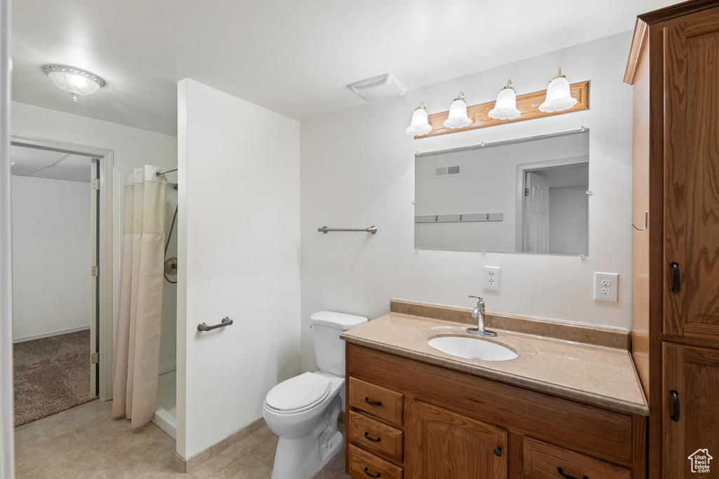 Bathroom featuring tile flooring, vanity, and toilet