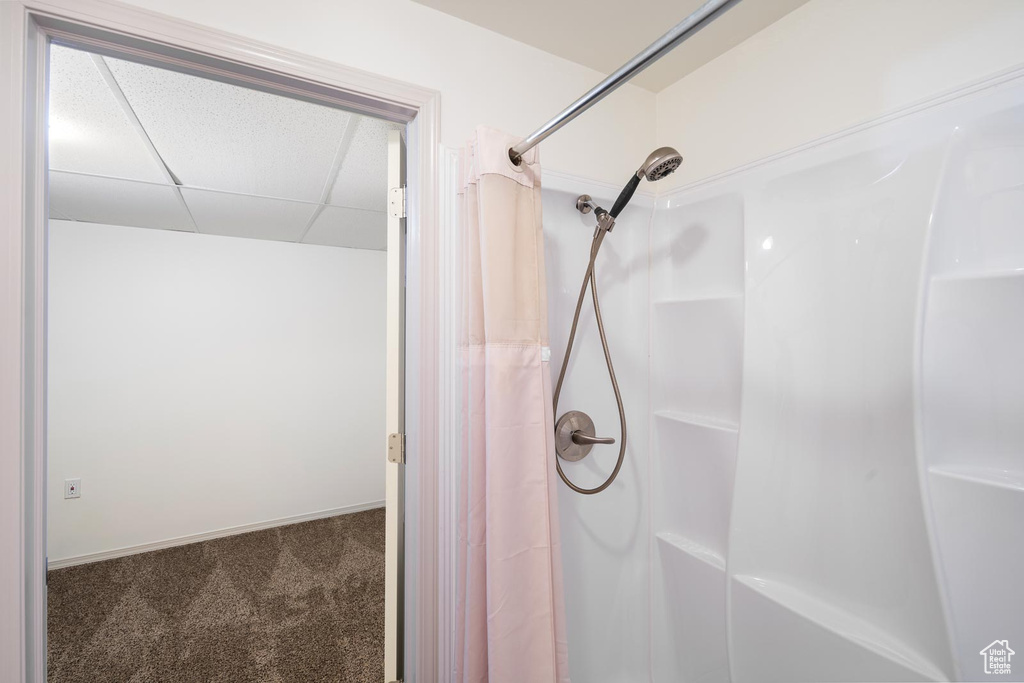 Bathroom with a shower with curtain and a paneled ceiling