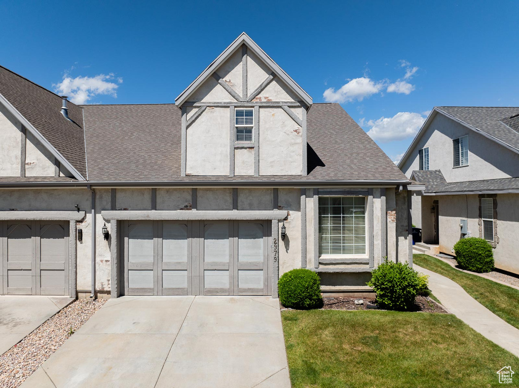 View of front of home with a garage and a front lawn