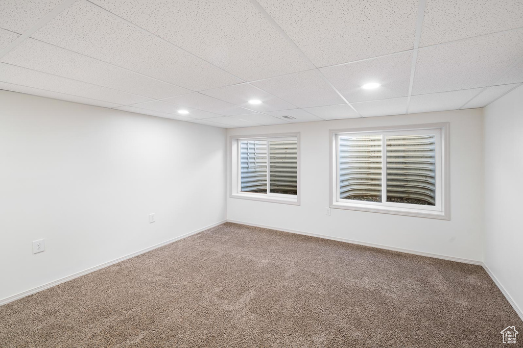 Spare room with carpet flooring and a paneled ceiling