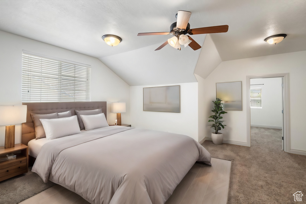 Bedroom with carpet flooring, ceiling fan, and lofted ceiling