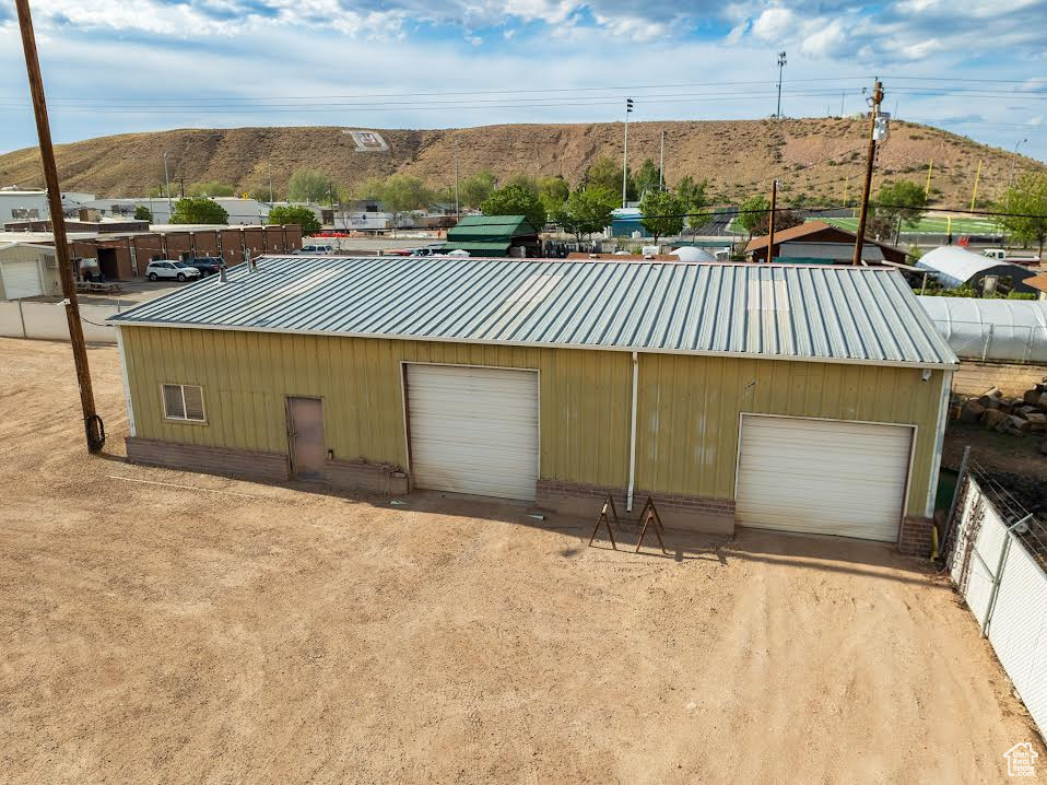 Exterior space with a garage, a mountain view, and an outdoor structure