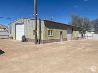 Rear view of property with a garage and an outdoor structure