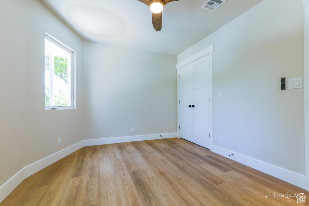 Empty room with light wood-type flooring and ceiling fan