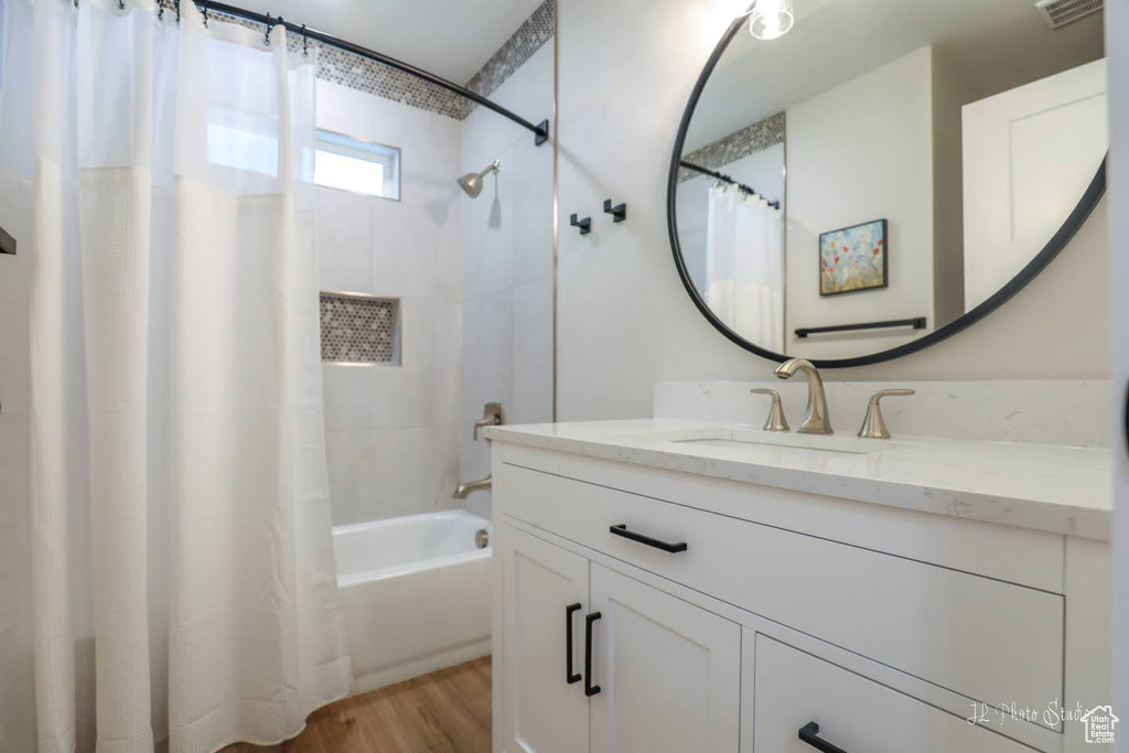 Bathroom featuring shower / bath combo, wood-type flooring, and oversized vanity