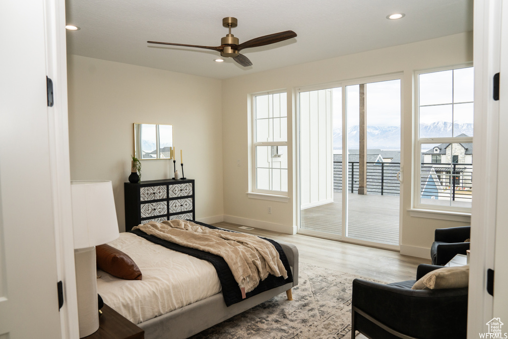 Bedroom featuring ceiling fan, multiple windows, and hardwood / wood-style floors