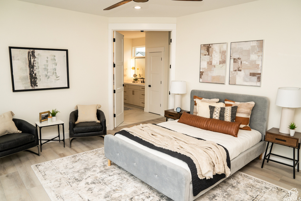 Bedroom featuring ceiling fan, ensuite bath, and wood-type flooring