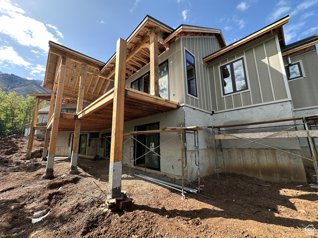 Back of property featuring a balcony and a mountain view