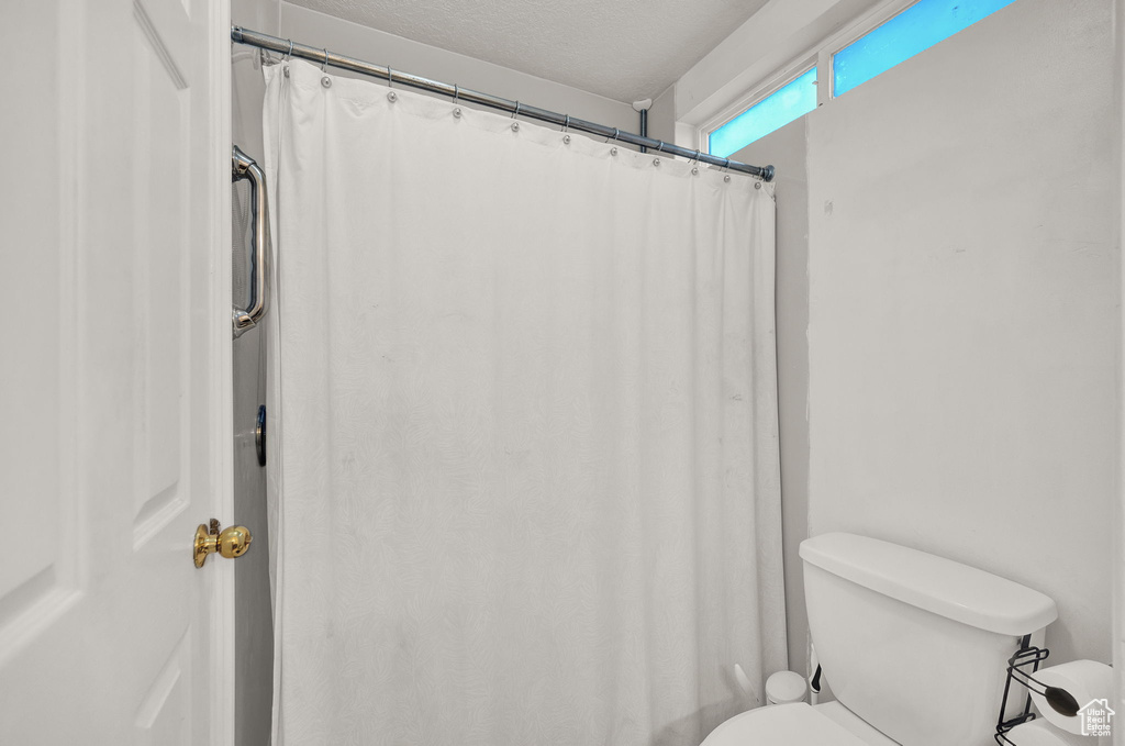 Bathroom with toilet and a textured ceiling