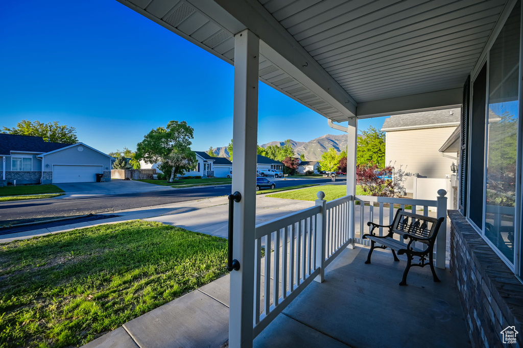 View of terrace featuring a garage, a mountain view, and covered porch