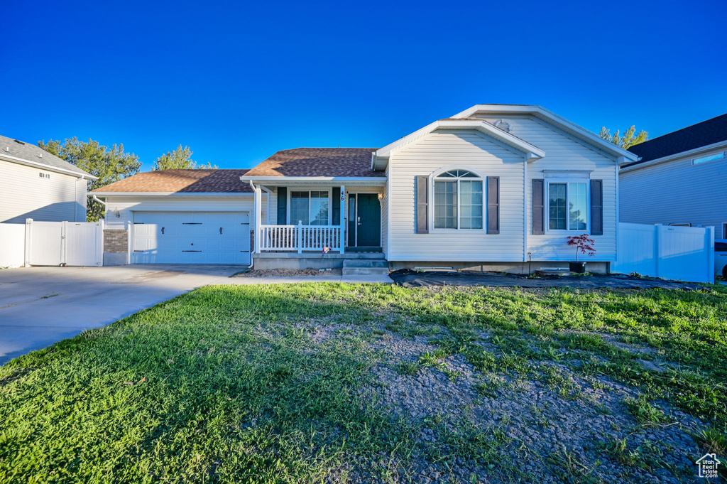 Ranch-style house featuring a garage and a front lawn