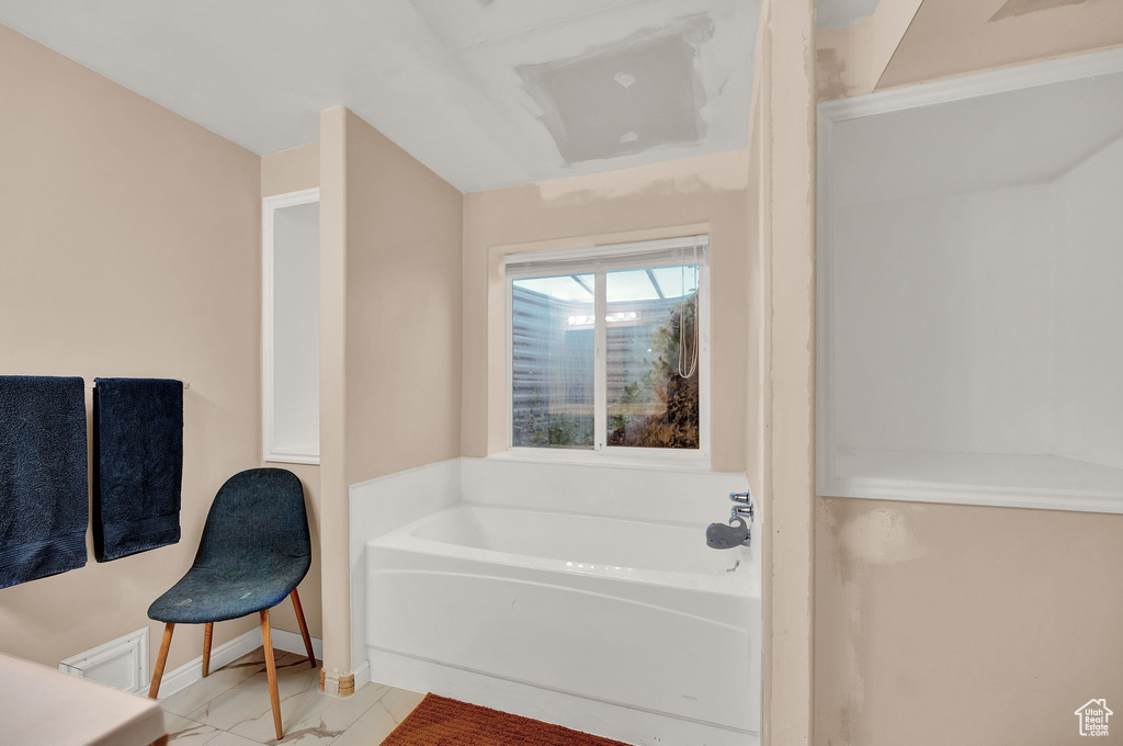 Bathroom featuring tile floors and a washtub