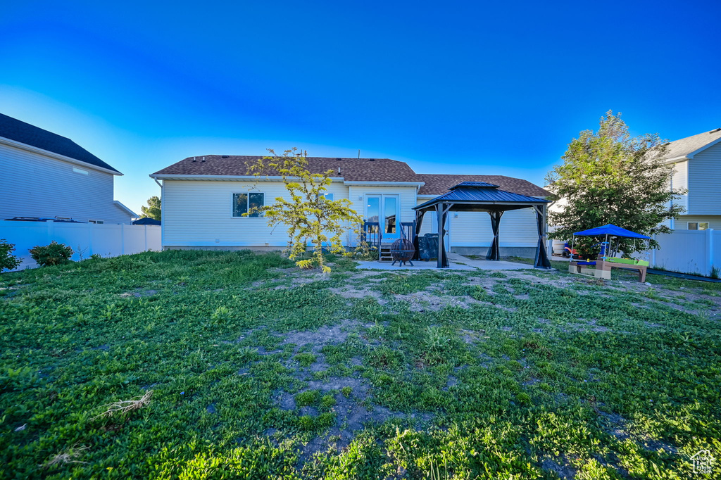 Rear view of property with a patio, a gazebo, and a lawn