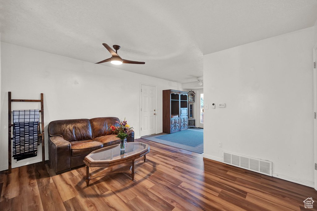 Living room with dark wood-type flooring and ceiling fan