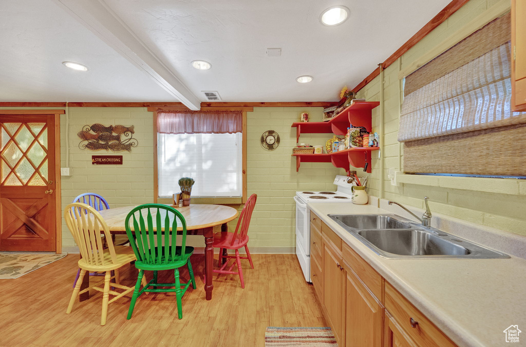 Kitchen with electric range, sink, light wood-type flooring, and beam ceiling