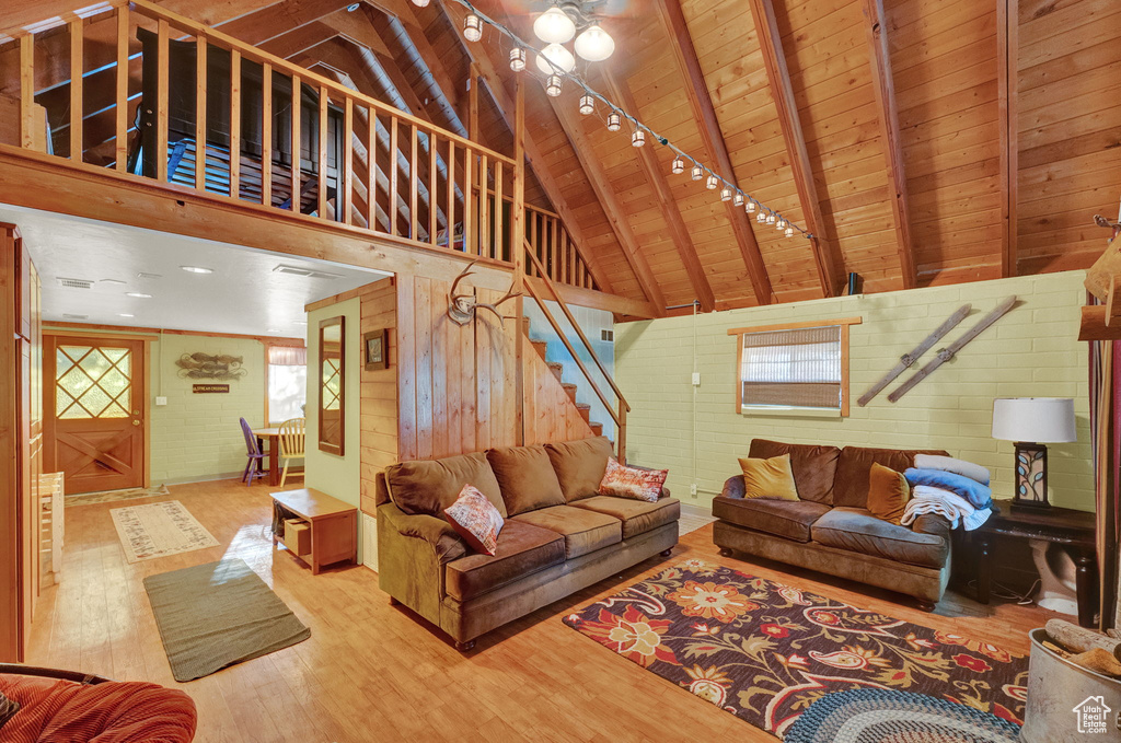 Living room featuring wooden ceiling, a wealth of natural light, hardwood / wood-style flooring, and wood walls