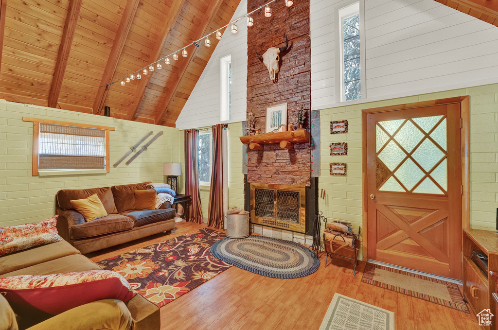 Living room featuring high vaulted ceiling, plenty of natural light, and wood ceiling