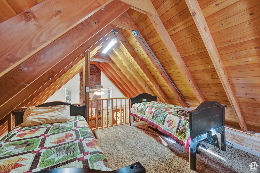 Carpeted bedroom featuring vaulted ceiling with beams and wood ceiling