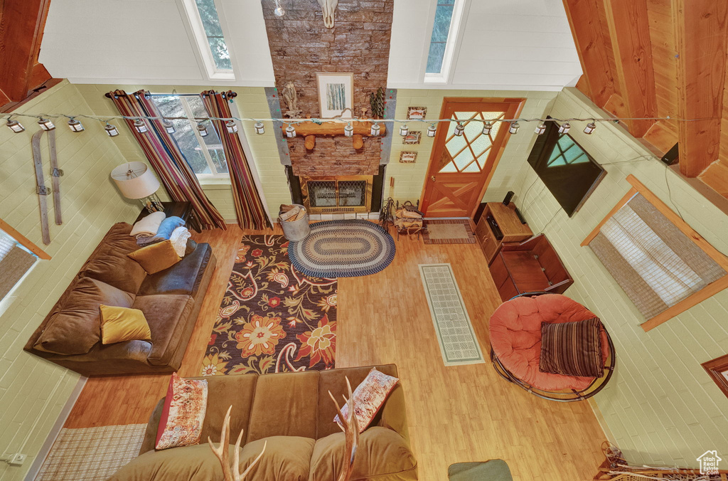 Living room with a high ceiling, hardwood / wood-style floors, and a large fireplace