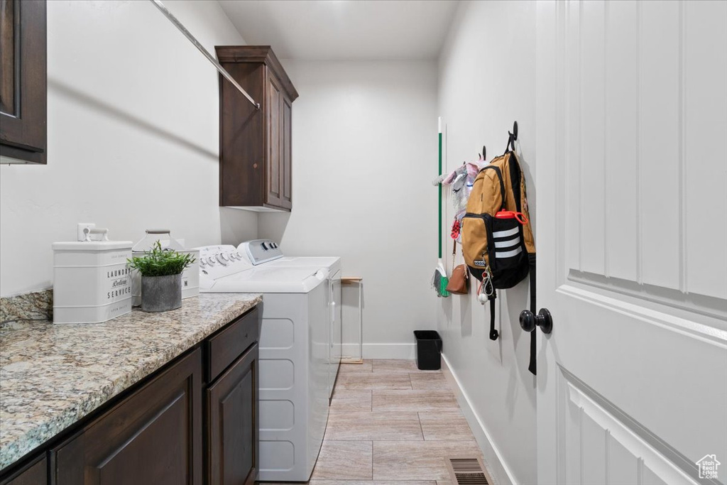 Laundry room with separate washer and dryer and cabinets