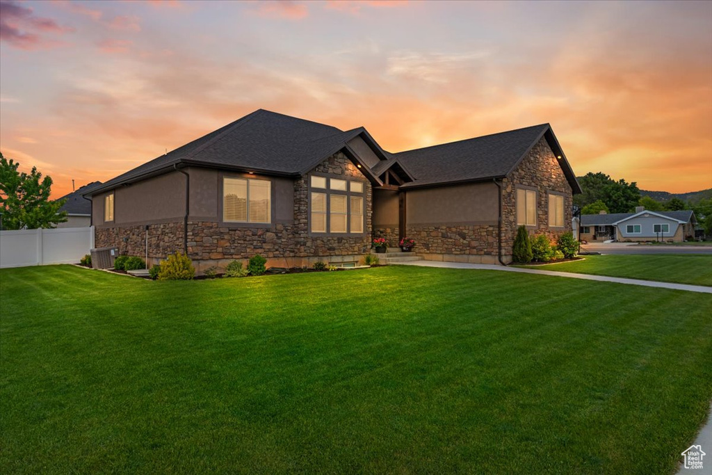 View of front of home featuring a yard and central air condition unit