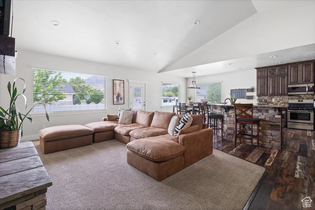 Living room featuring high vaulted ceiling and dark wood-type flooring