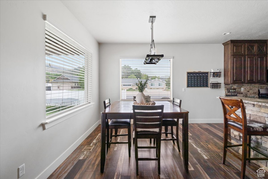 Dining area with dark wood-type flooring