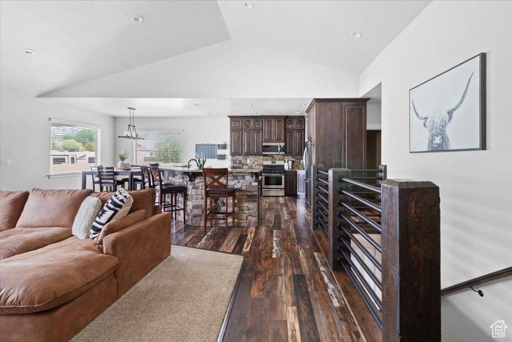 Living room with high vaulted ceiling, dark hardwood / wood-style flooring, and a chandelier