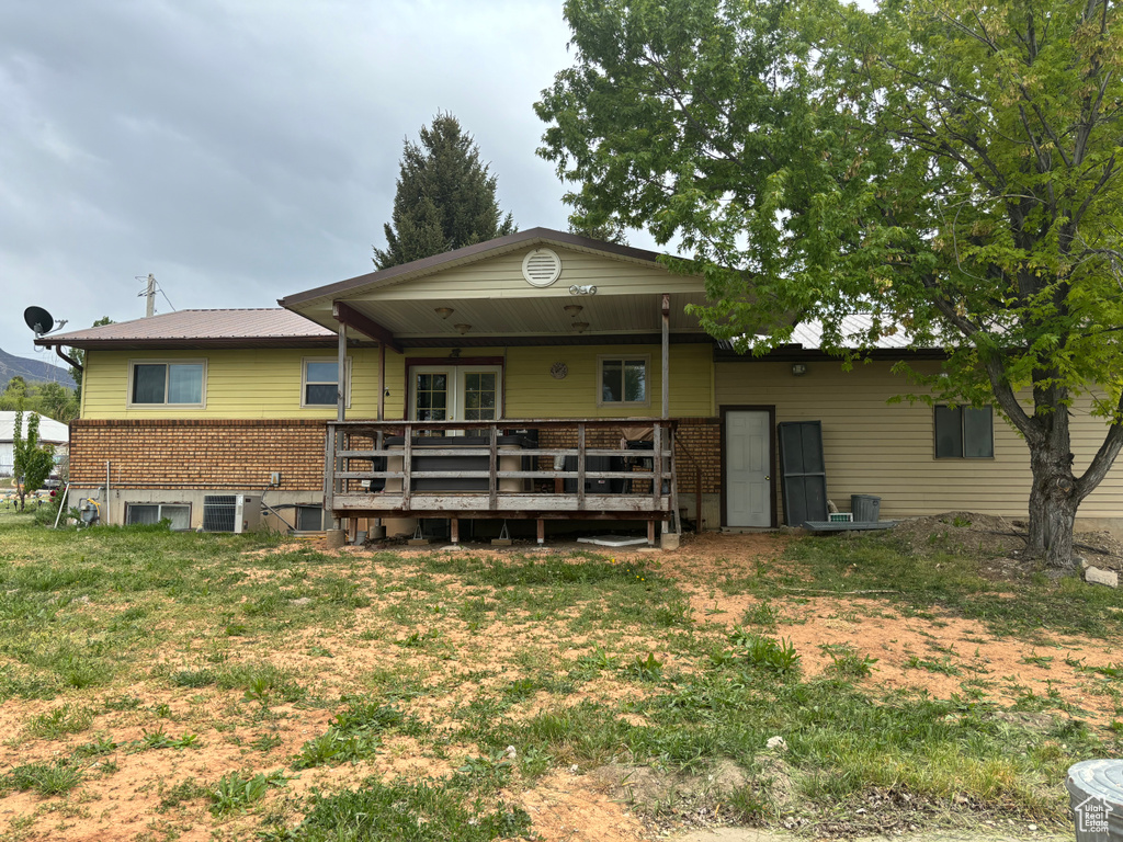 Back of property with a deck and a yard