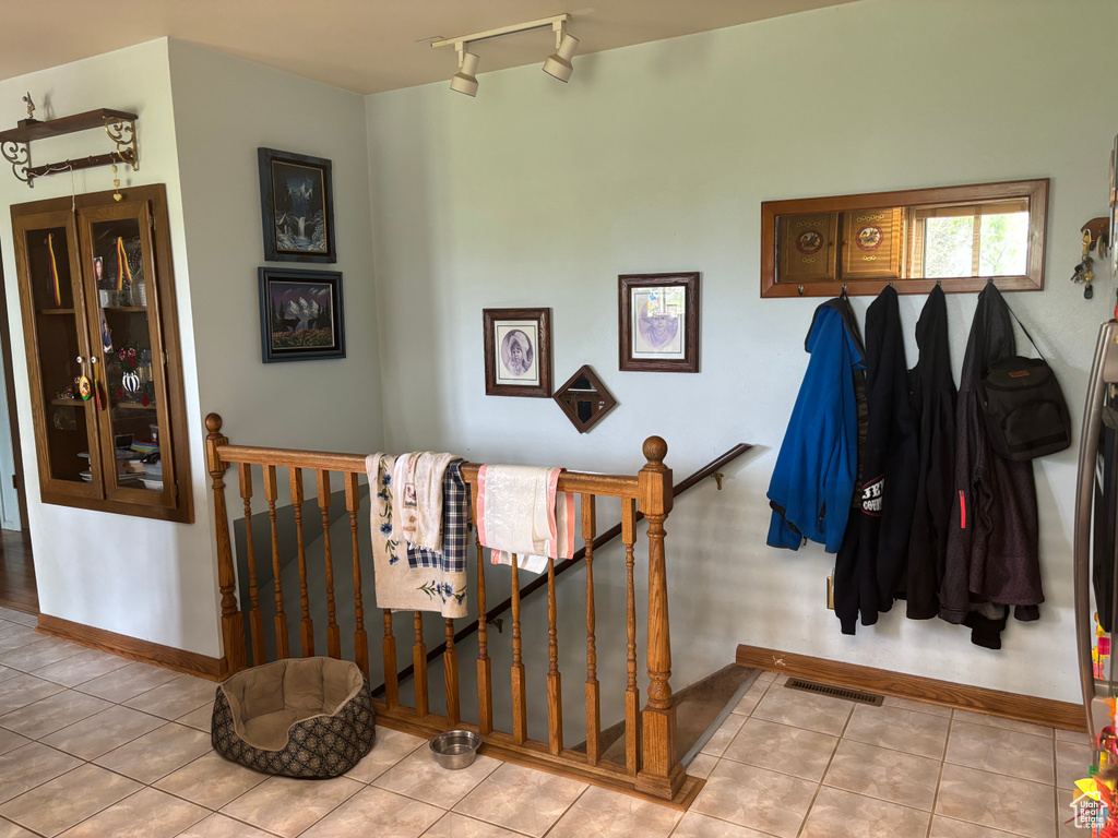 Stairs with track lighting and tile floors