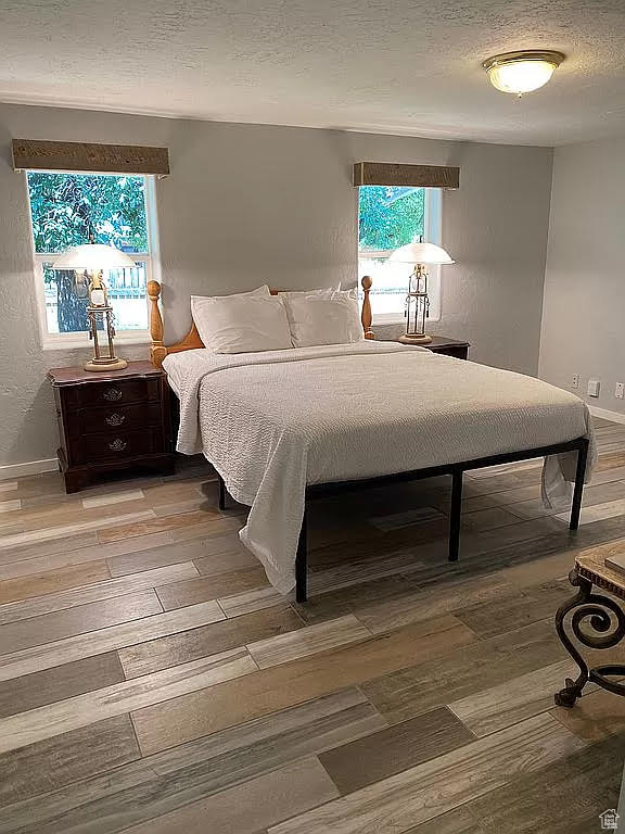 Bedroom featuring light hardwood / wood-style flooring and a textured ceiling