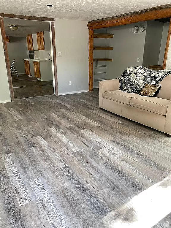 Unfurnished living room with hardwood / wood-style flooring and a textured ceiling